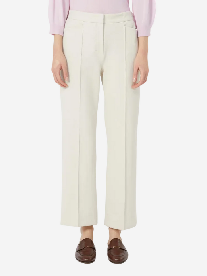 Person wearing white pants and a pink top on a white background