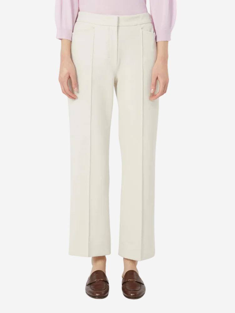 Person wearing white pants and a pink top on a white background