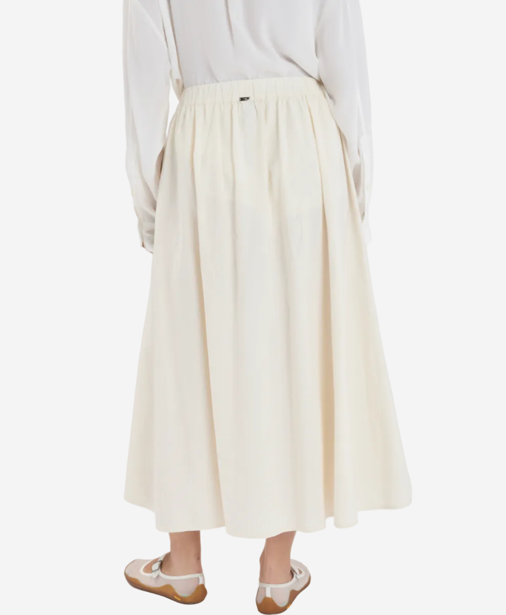 Person wearing a white shirt and beige skirt on a white background