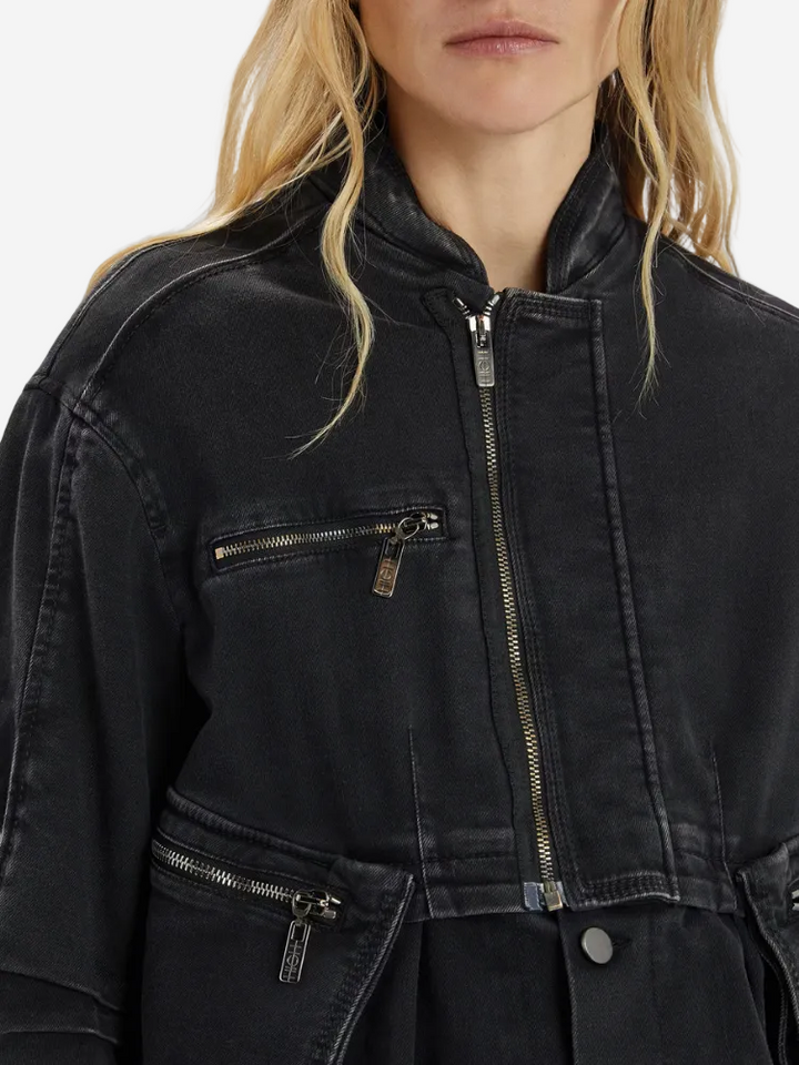 Black jacket with zippers worn by a person on a light gray background