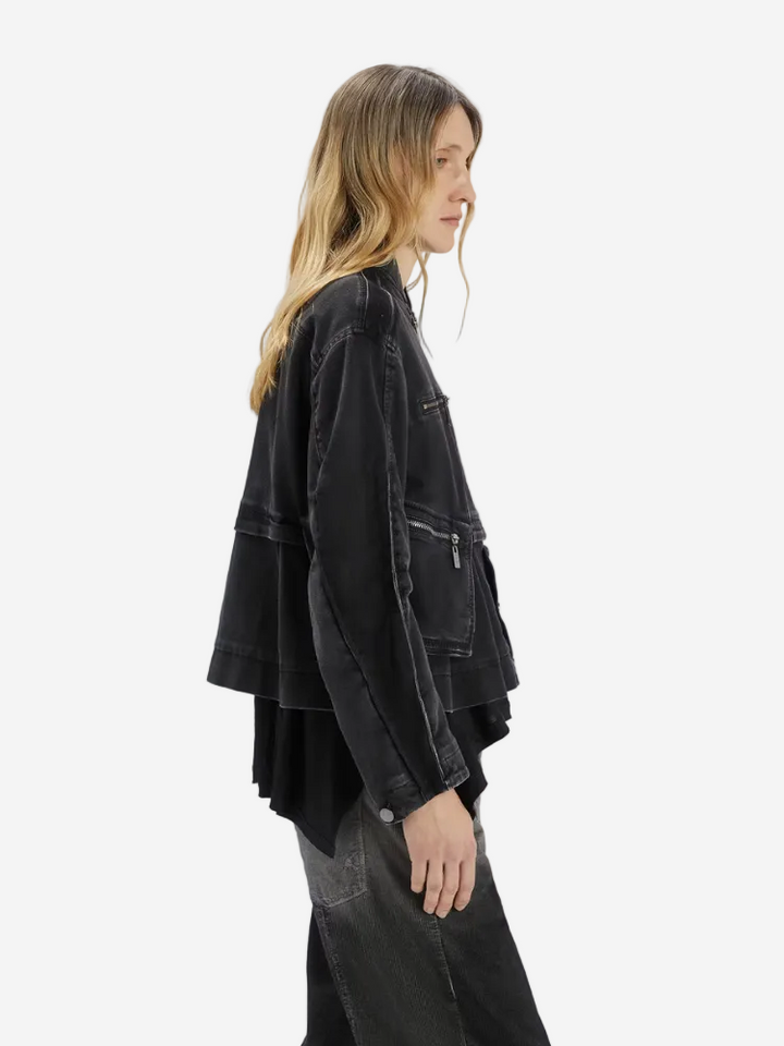 Person wearing a black denim jacket on a white background