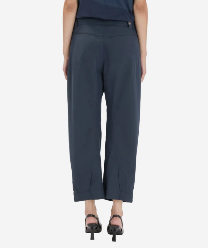 Person wearing navy blue pants on a white background