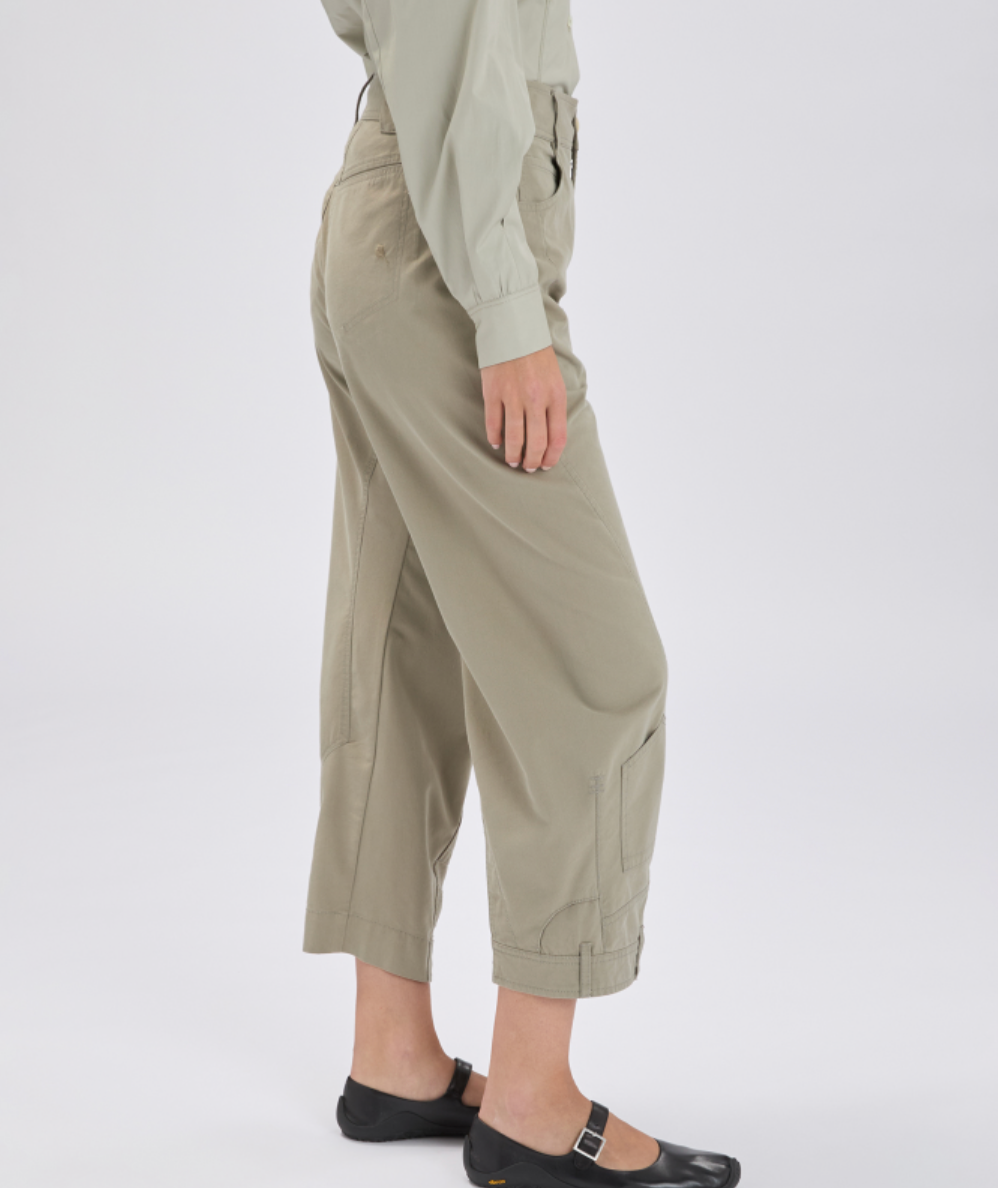 Person wearing beige cargo pants and a light green shirt on a white background