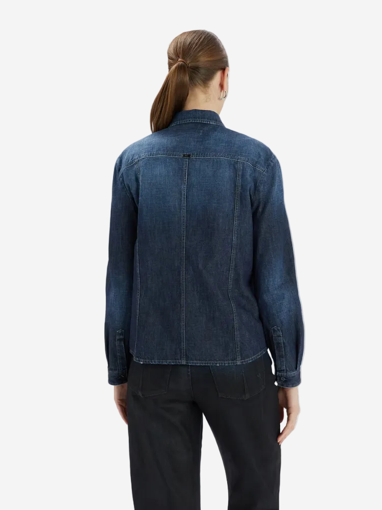 Person wearing a blue denim jacket on a white background
