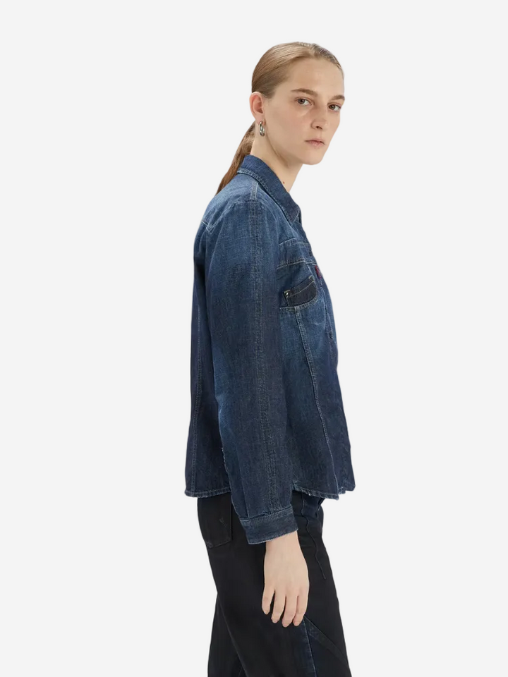 Person wearing a blue denim jacket on a white background