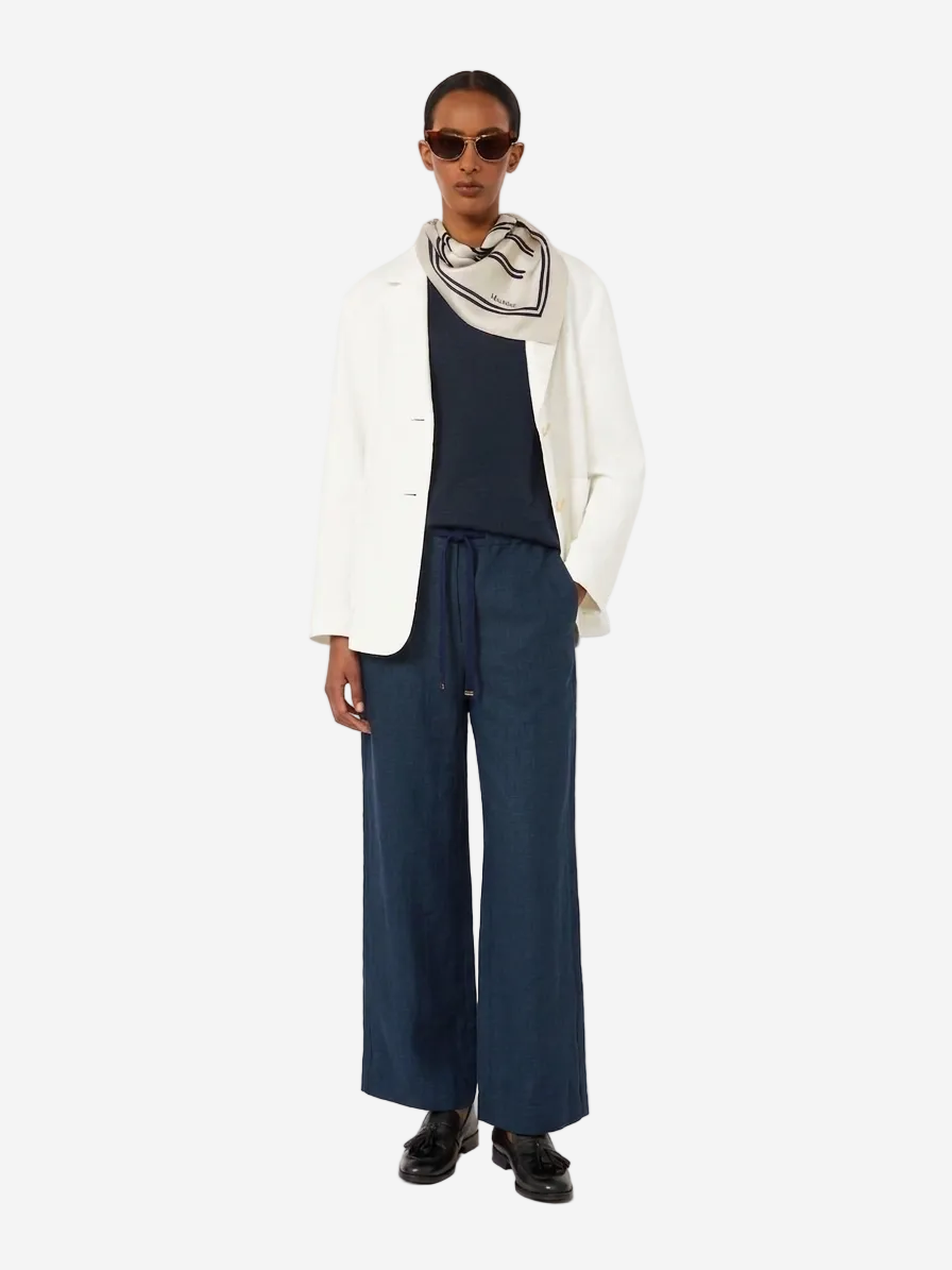 Person wearing a white top, navy pants, and sunglasses on a white background