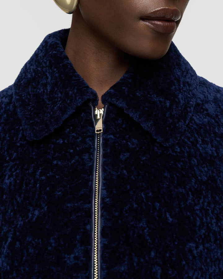 Close-up of the shearling collar and gold zip on the JOSEPH Liris jacket in Prussian blue