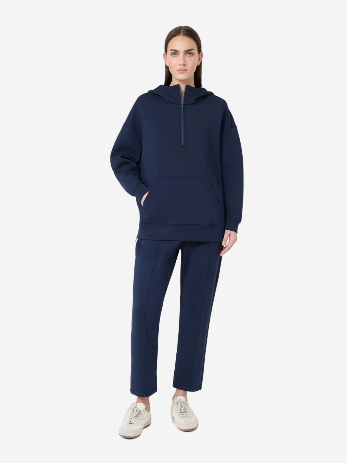 Person wearing a navy blue hoodie and pants on a white background
