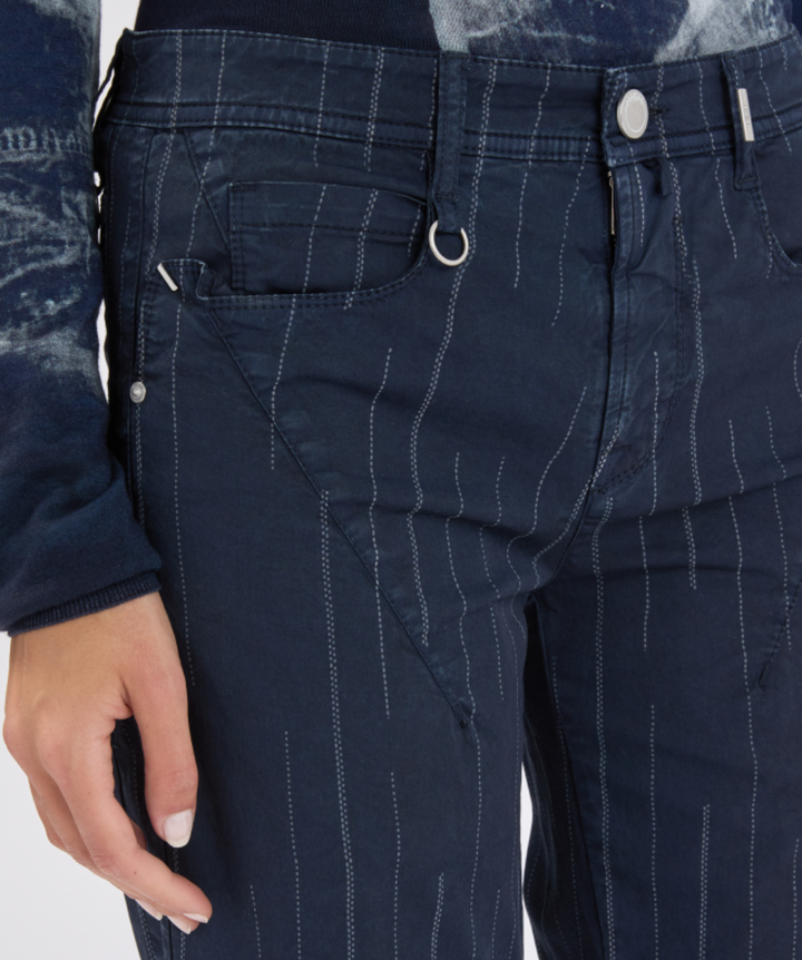 Navy pinstripe pants with a close-up of a pocket and button.