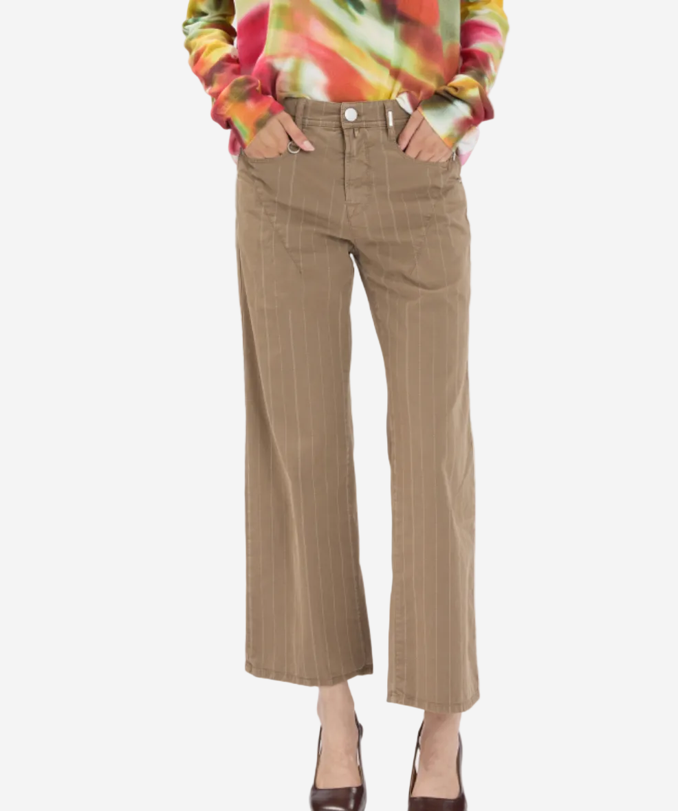Person wearing a colorful sweater and beige striped pants on a white background