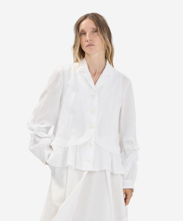 Woman wearing a white outfit against a plain background