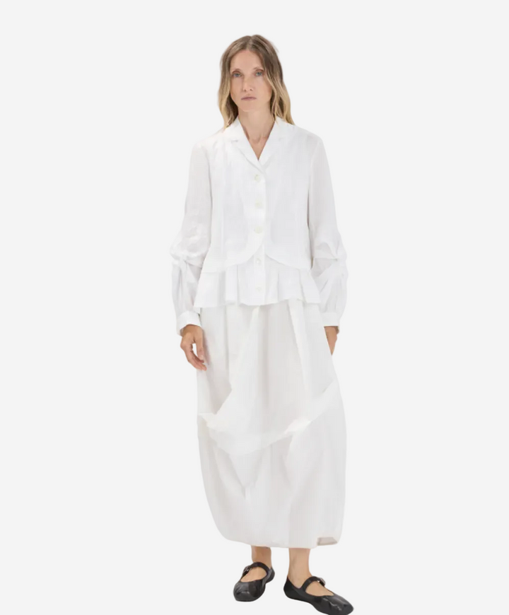 Woman wearing a white outfit on a plain background