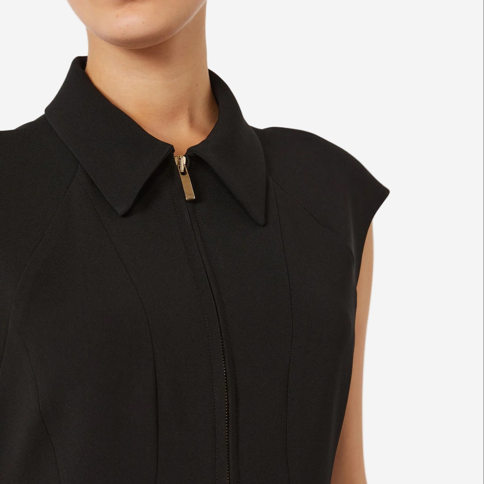 Black sleeveless dress with a collar and zipper detail on a white background