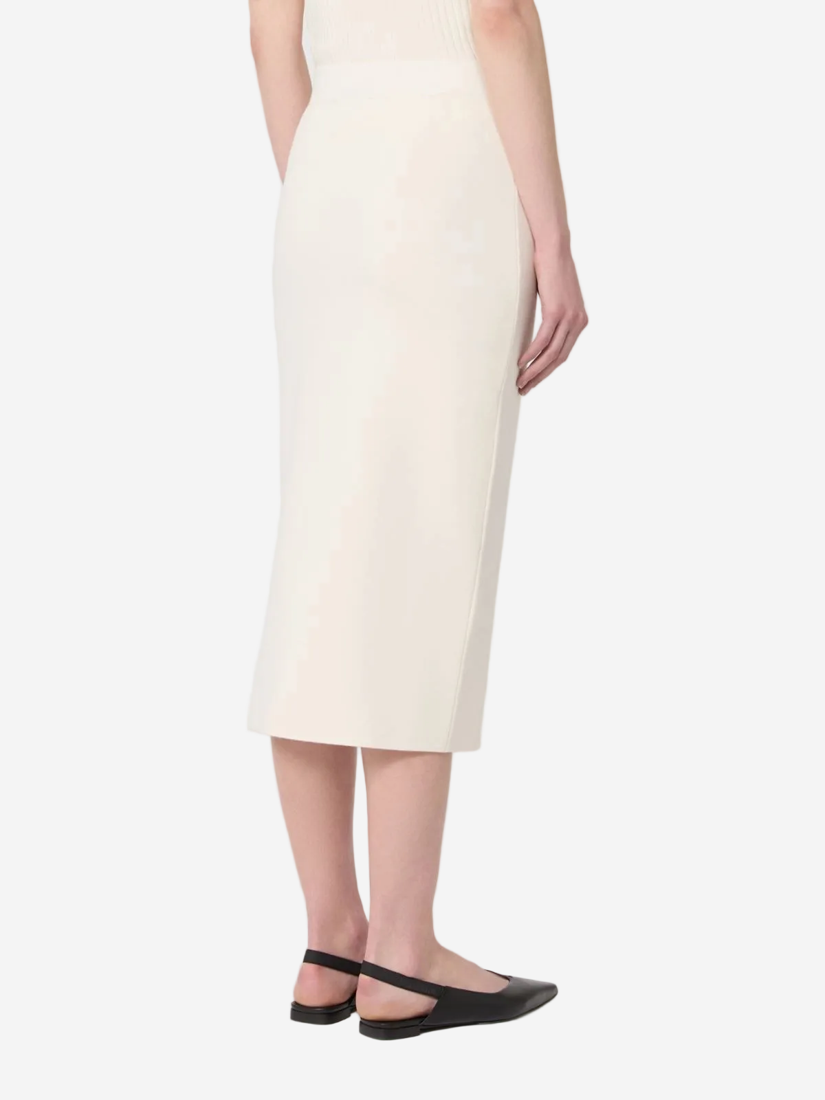 Person wearing a white dress with black shoes on a light gray background