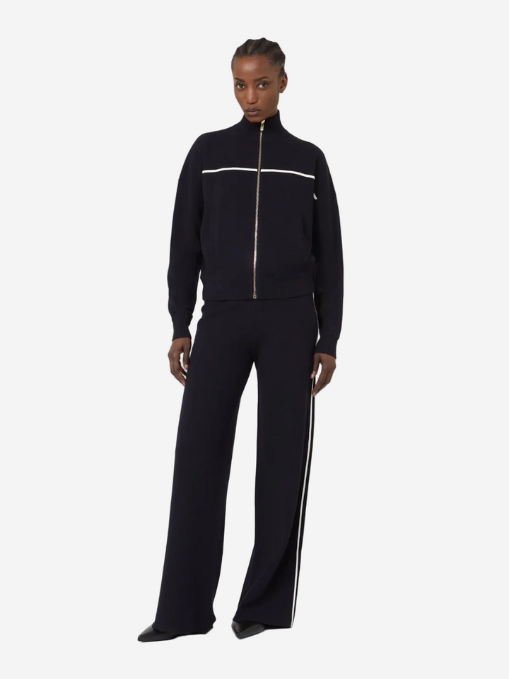 Person wearing a black tracksuit with white stripes on a white background
