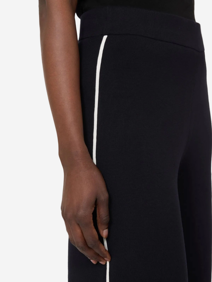 Black pants with a white stripe on a plain background