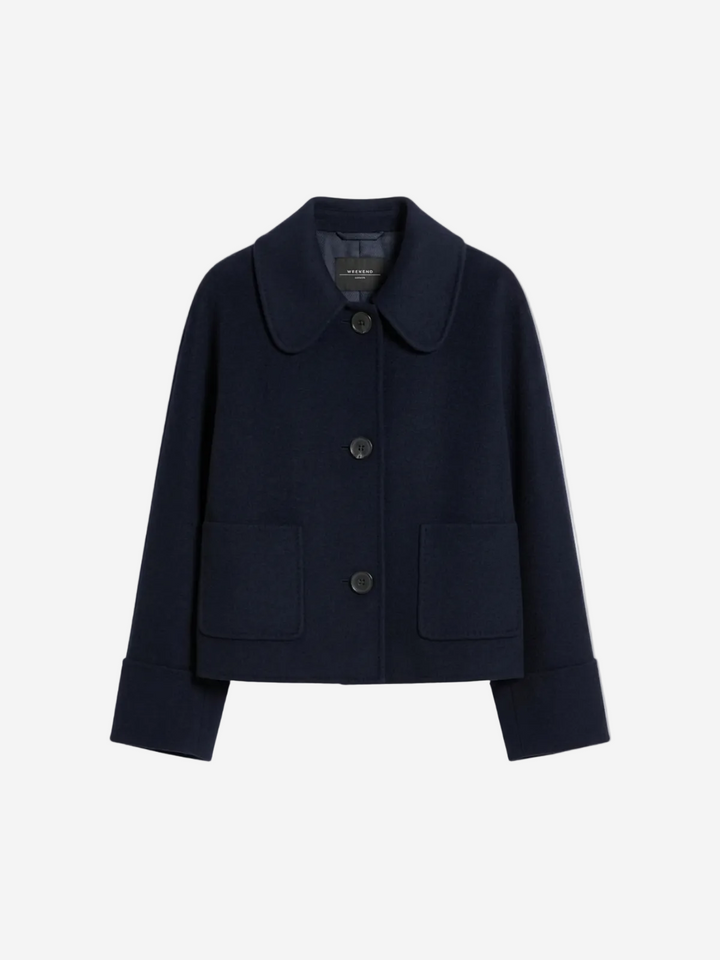 Navy blue coat with button details on a light gray background at Christensen Copenhagen