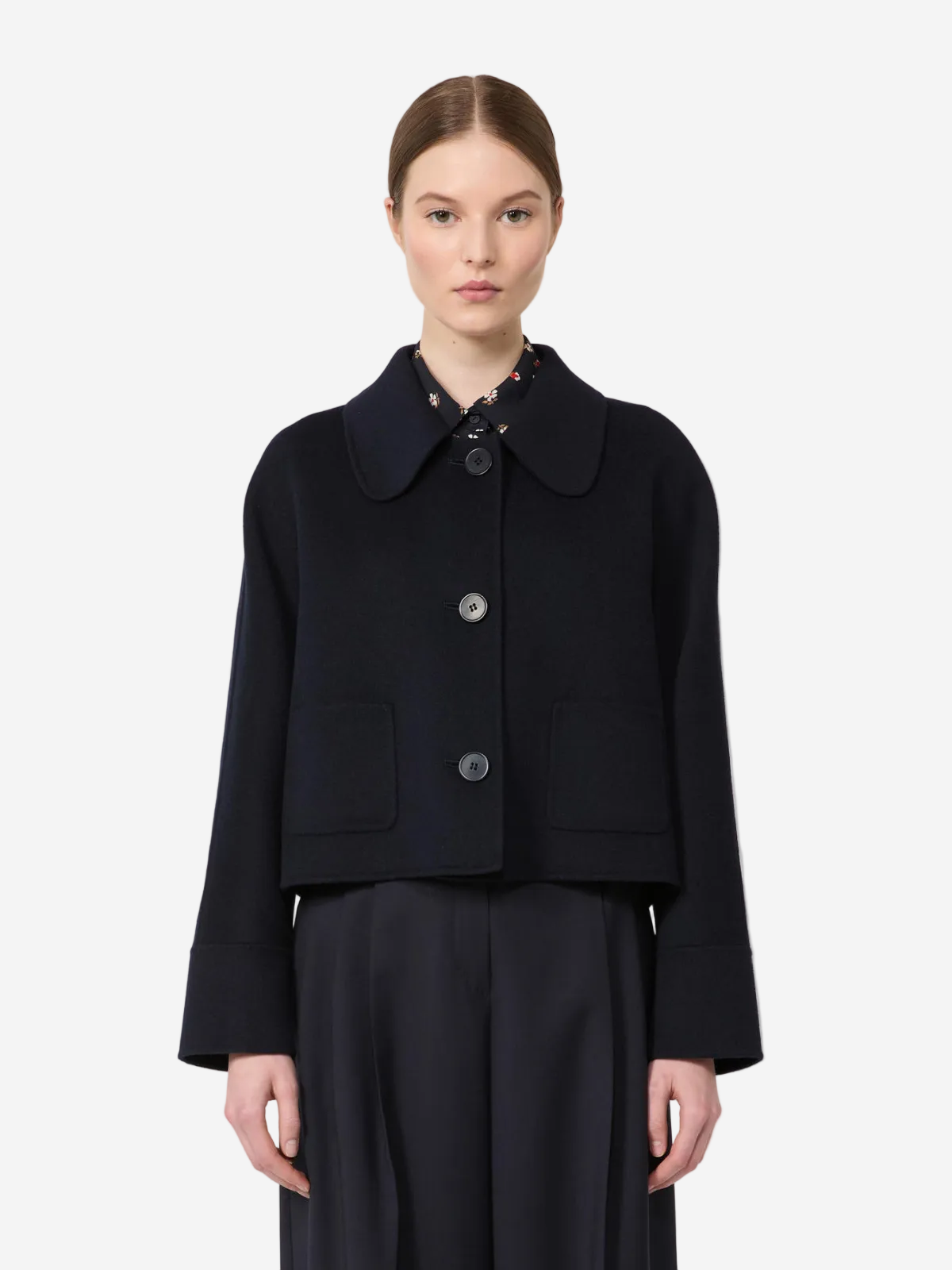 Woman wearing a black coat with a white background