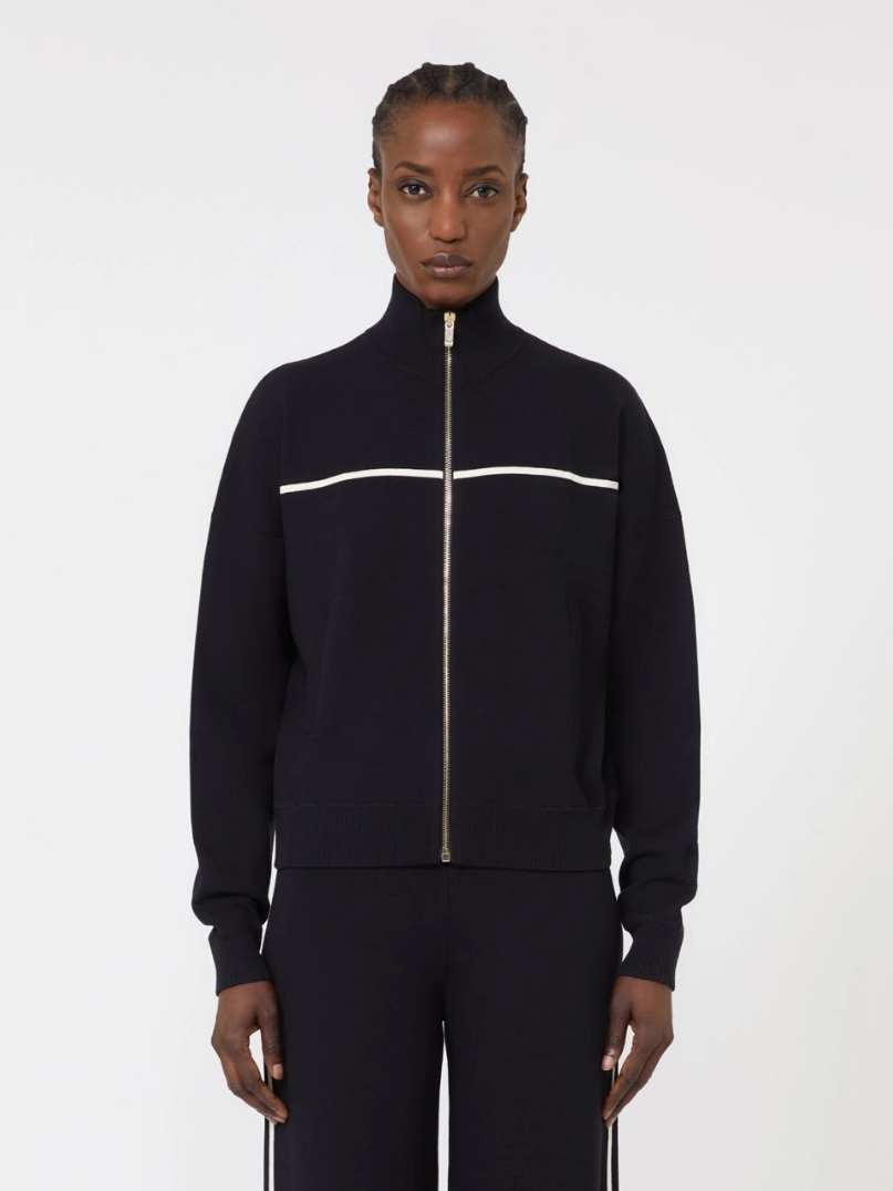 Person wearing a black tracksuit with a white stripe on a white background