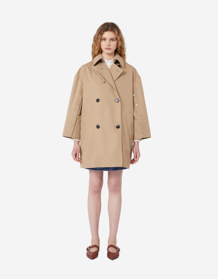 Woman wearing a beige trench coat on a white background