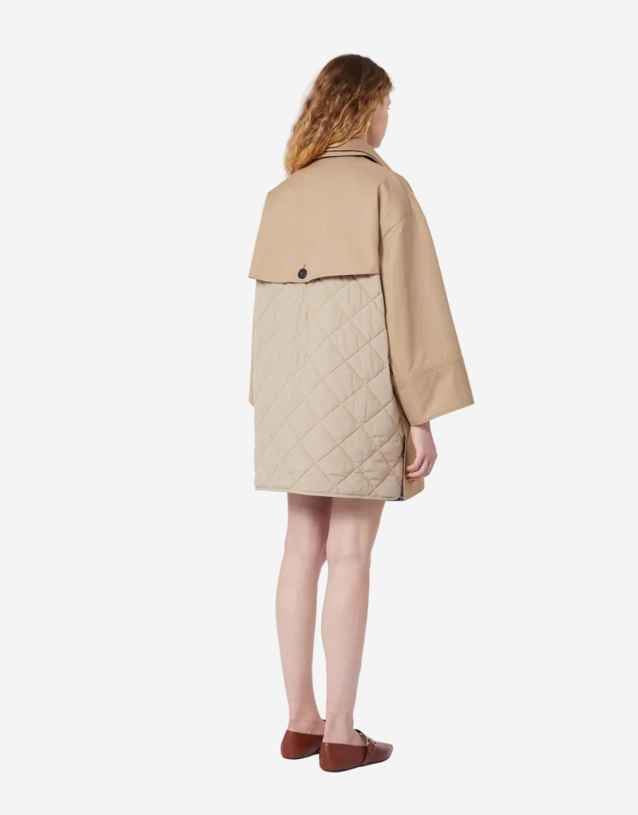 Person wearing a beige quilted coat on a white background