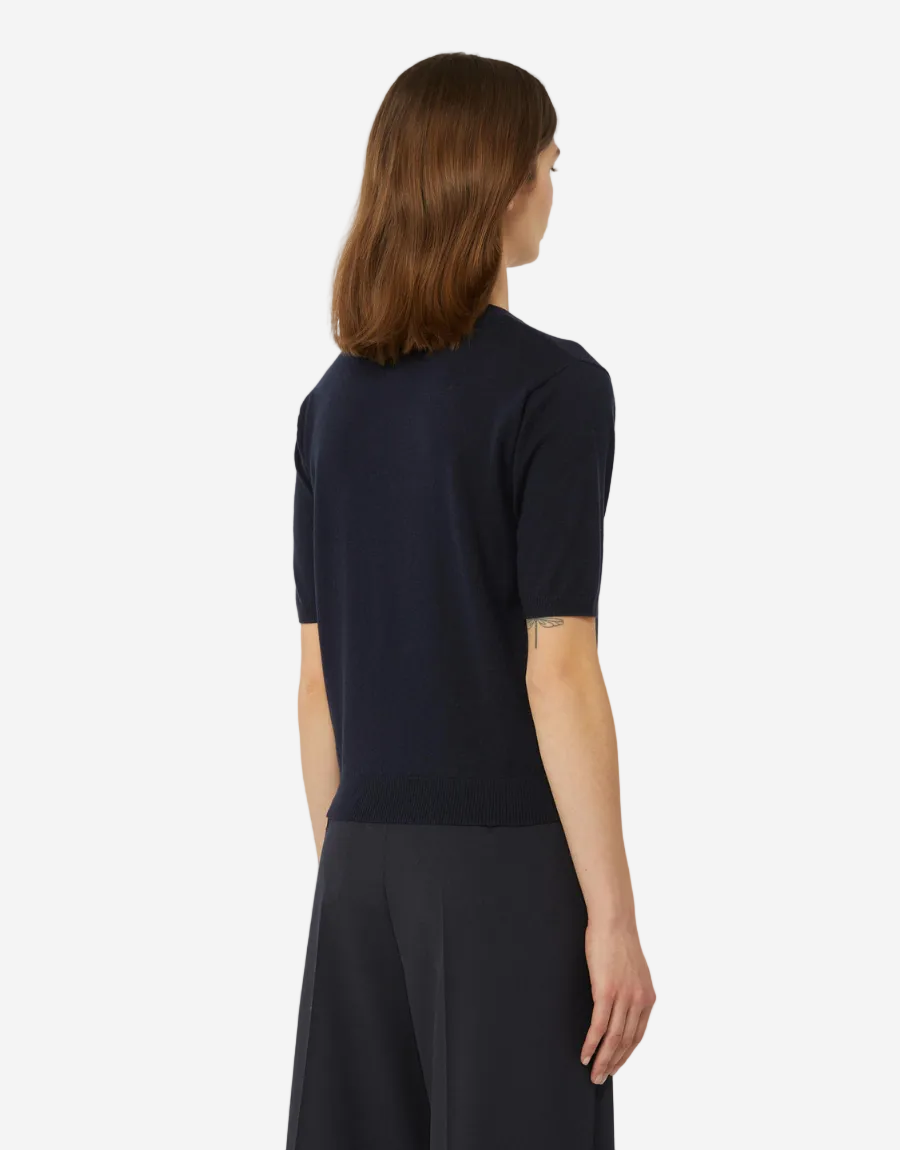 Woman wearing a black top and dark pants on a white background