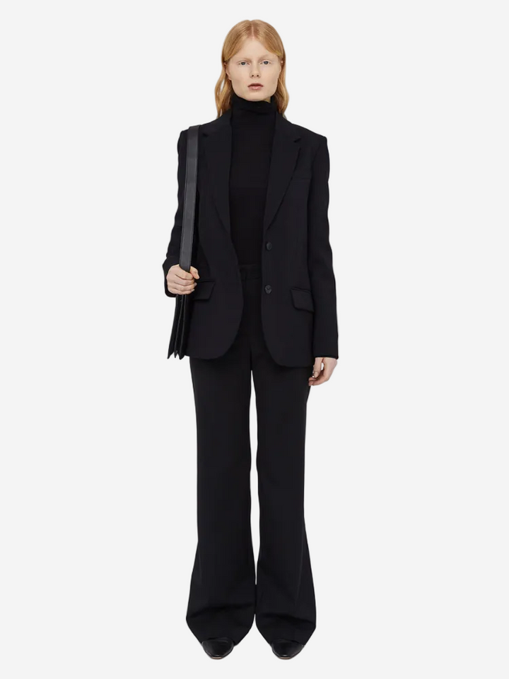 Person wearing a black suit with a white background