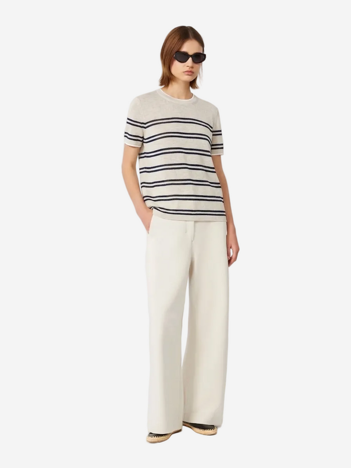 Person wearing a striped shirt and wide-leg pants on a white background