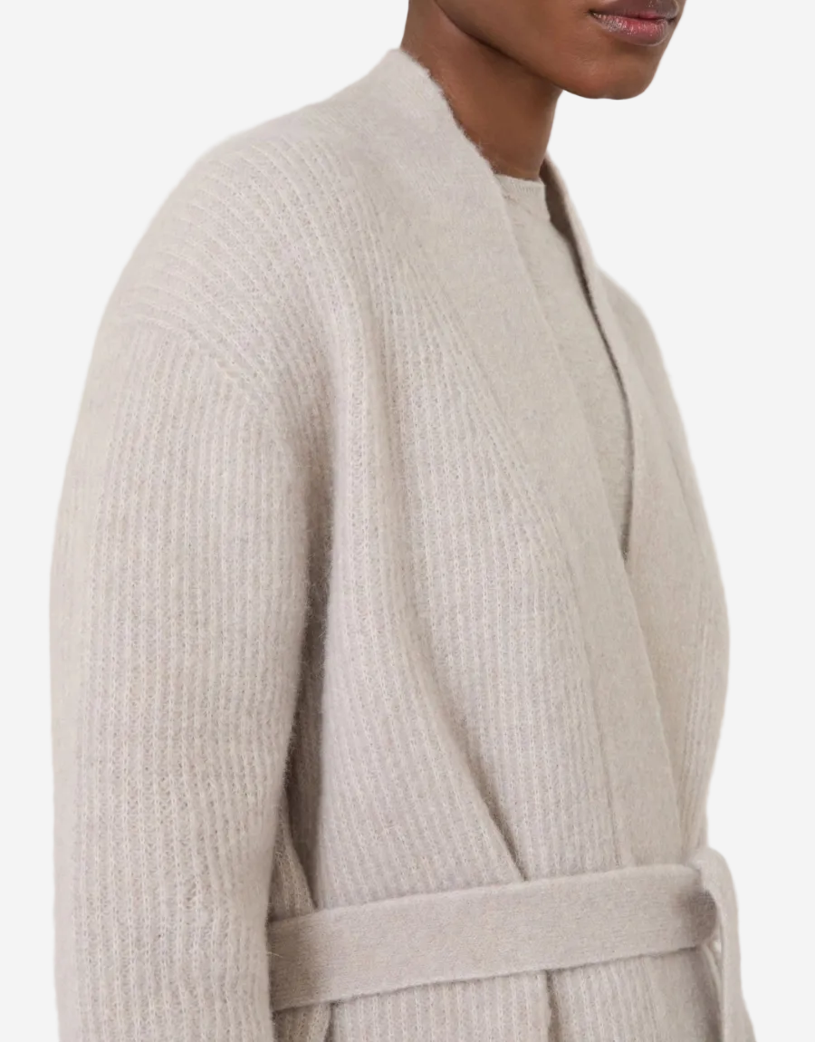 Beige robe worn by a person on a white background