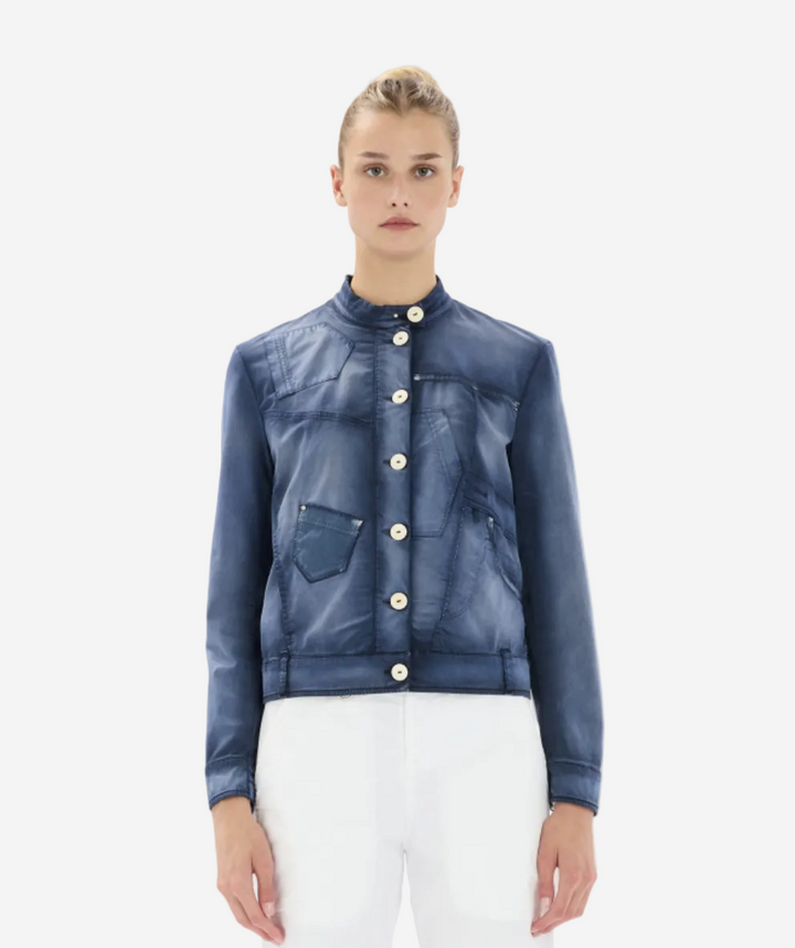 Woman wearing a blue denim jacket with white buttons on a white background