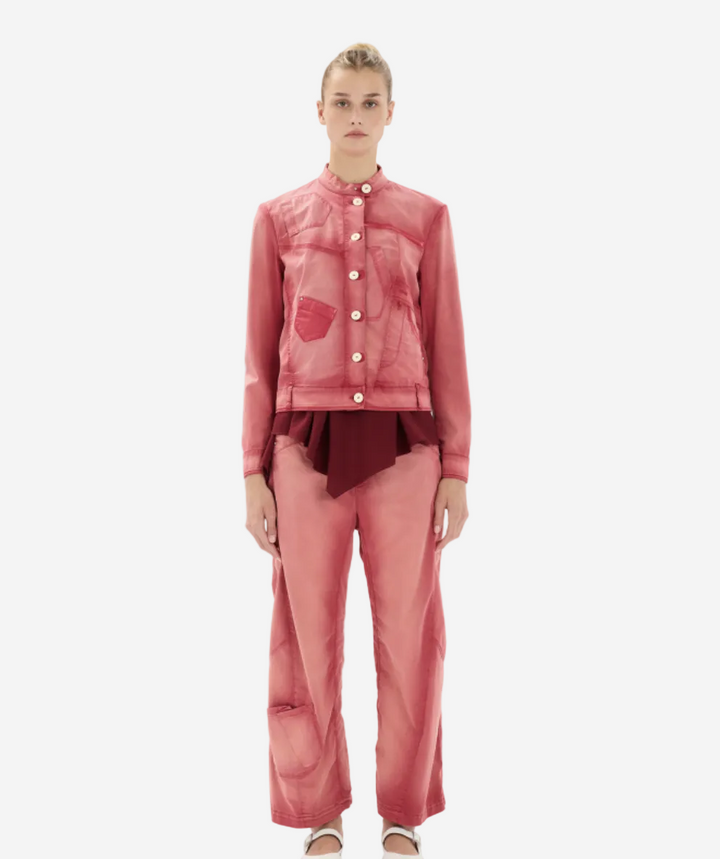 Woman wearing a pink outfit with a matching jacket and pants on a white background
