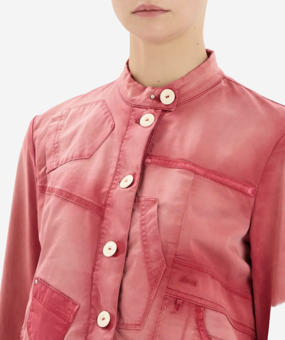 Close-up of a person wearing a pink jacket with button details on a white background