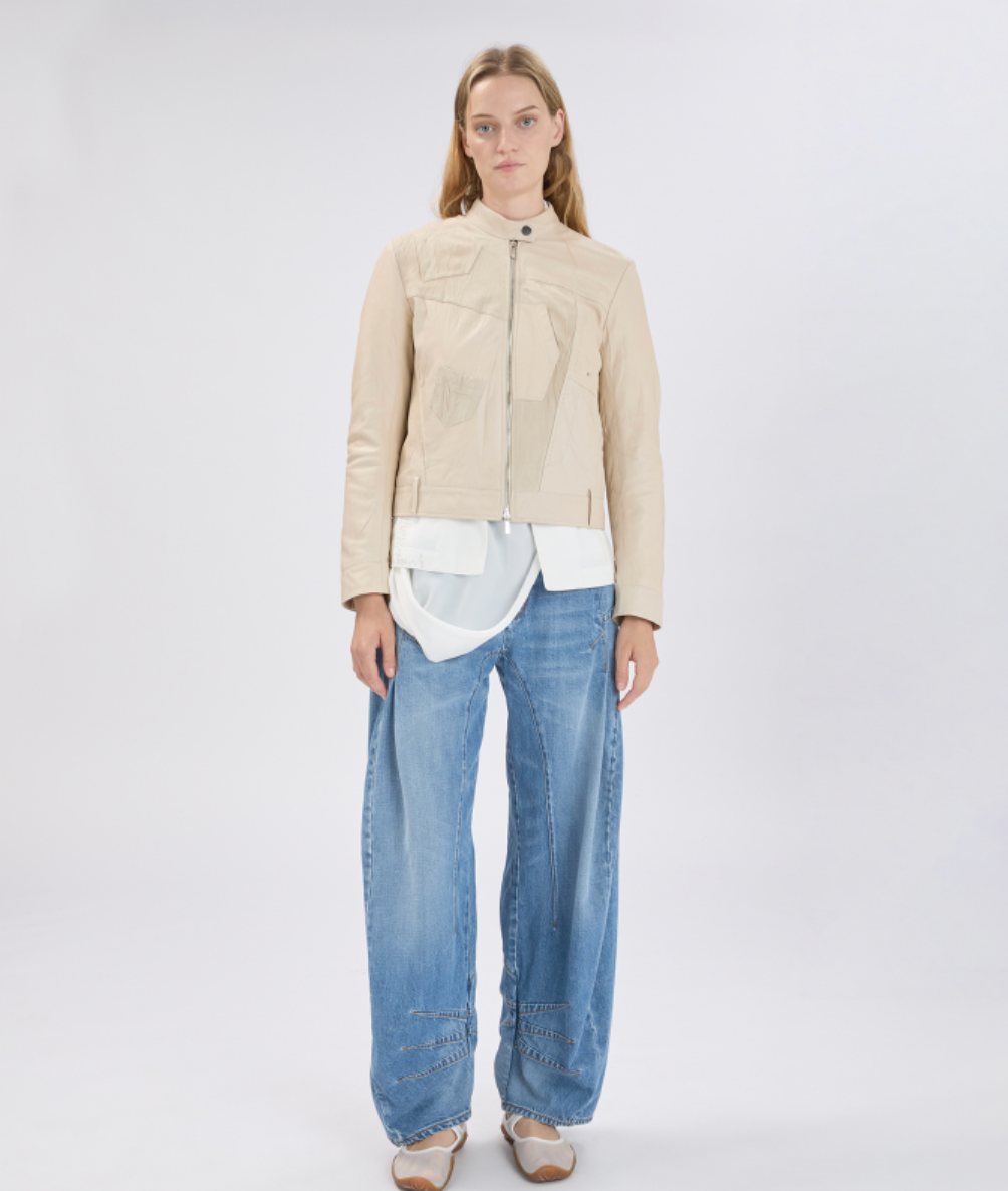 Woman wearing a beige jacket and blue jeans on a white background