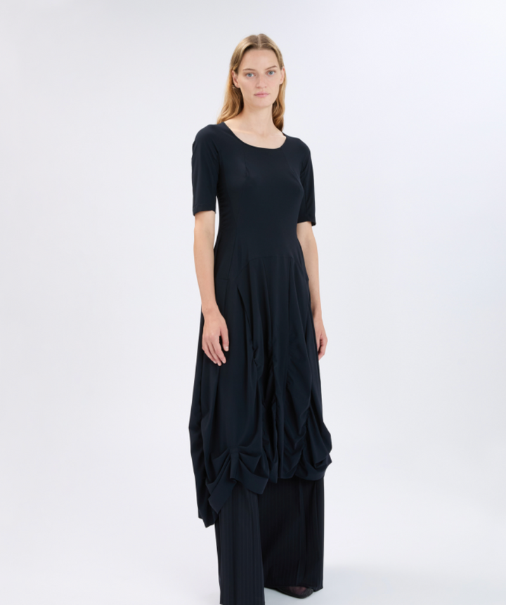 Woman wearing a black dress with a layered skirt on a white background