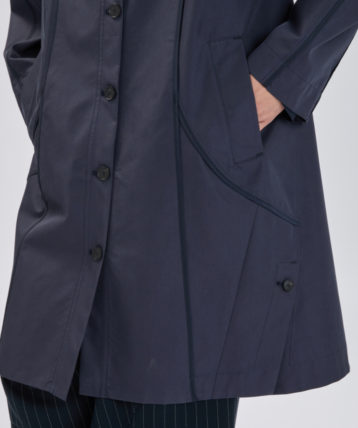 Navy blue raincoat with button details on a light gray background