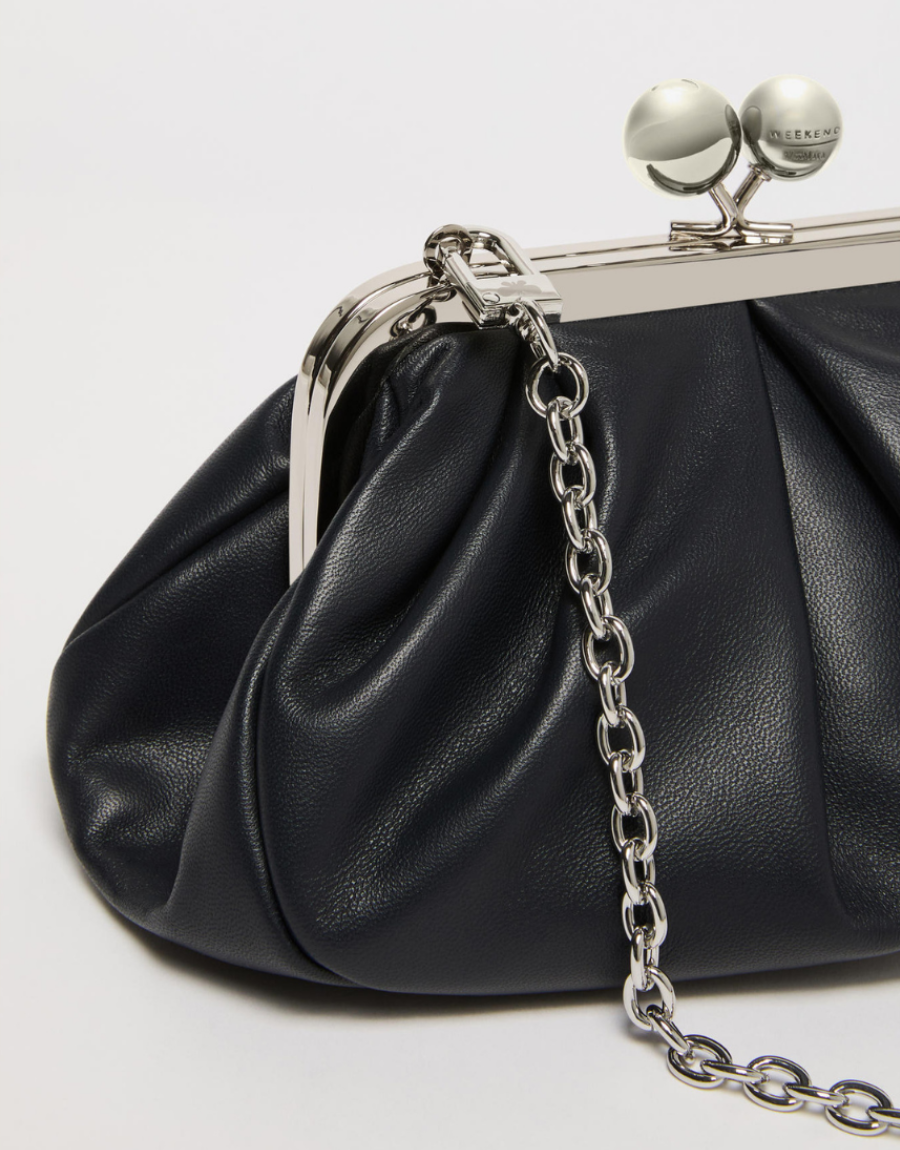 Black clutch bag with a silver chain and clasp on a light gray background