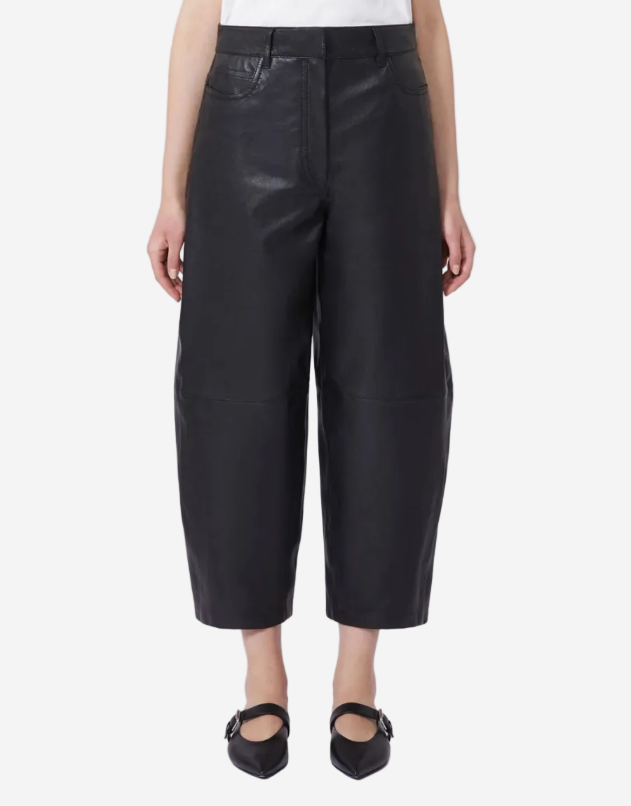 Person wearing black leather pants on a white background