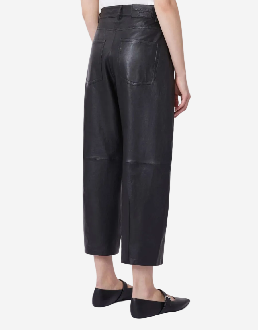 Person wearing black leather pants on a white background