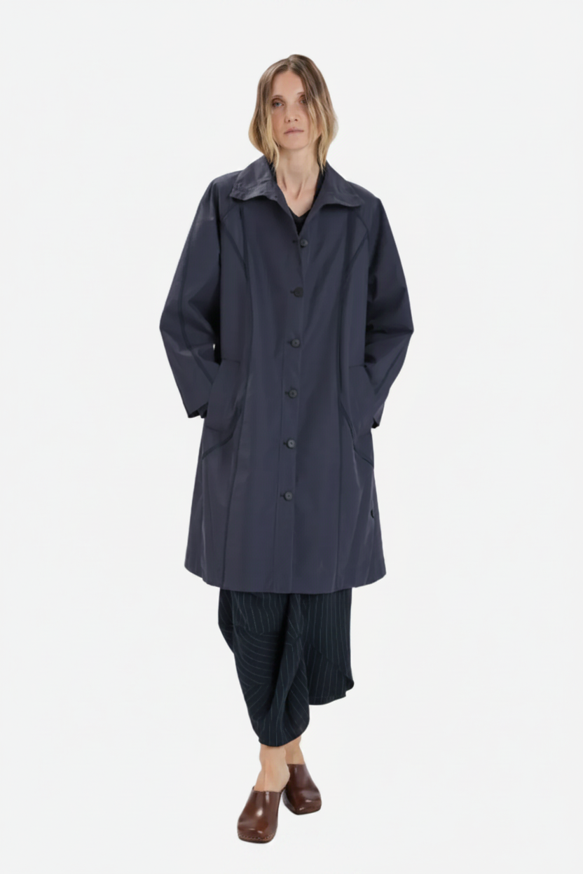Person wearing a long dark coat on a white background