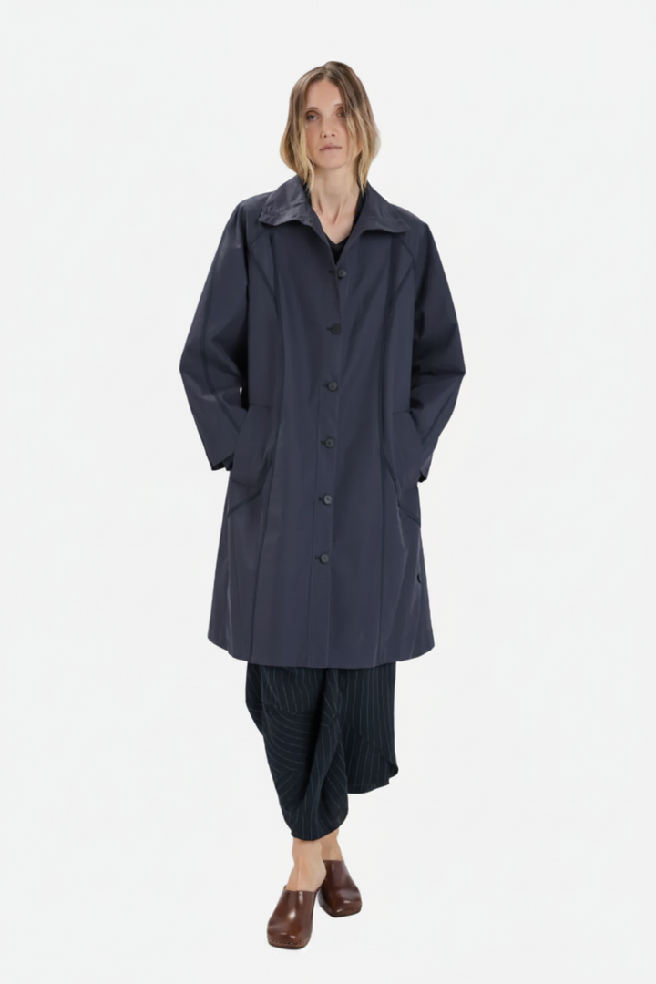 Person wearing a long dark coat on a white background