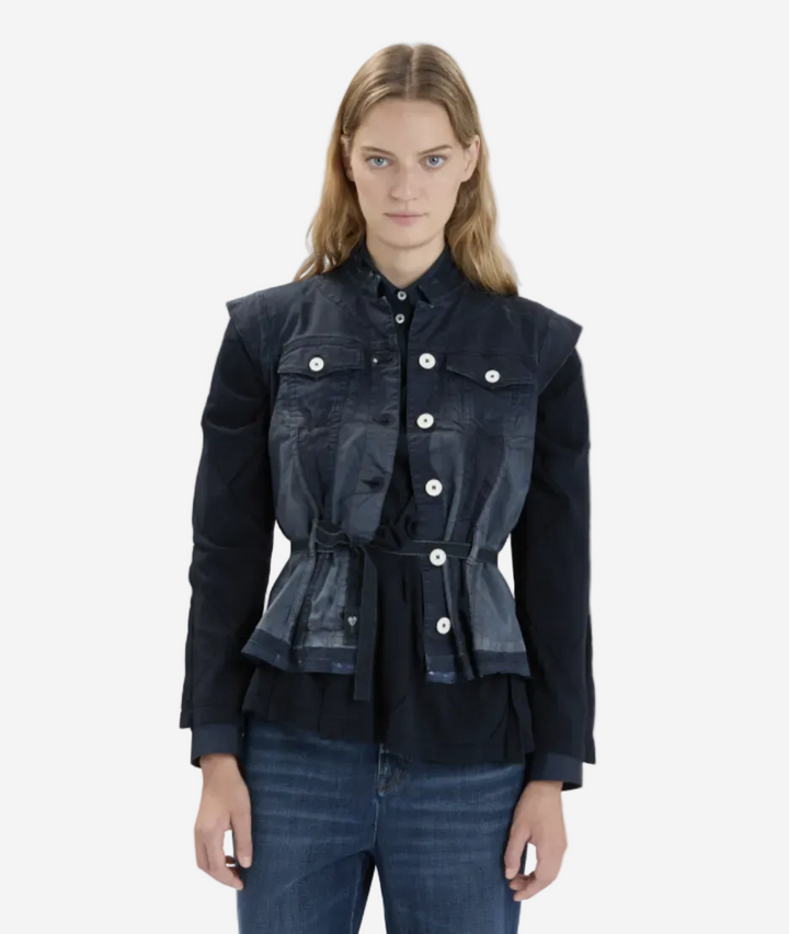 Woman wearing a dark denim jacket with layered design on a white background