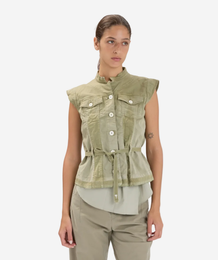 Woman wearing a light green sleeveless jacket with buttons on a white background
