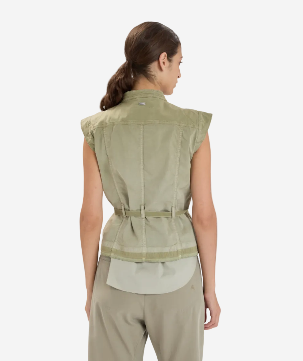 Woman wearing a green sleeveless jacket on a white background