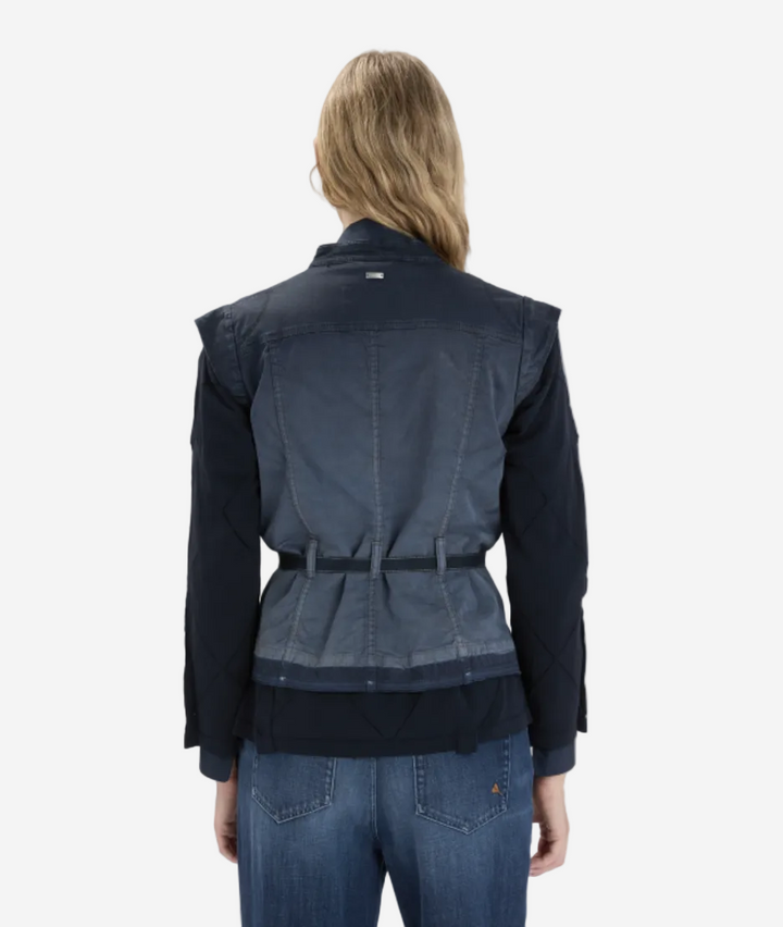 Person wearing a navy jacket and jeans on a white background