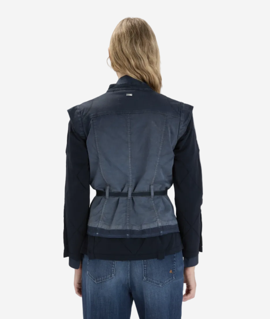 Person wearing a navy jacket and jeans on a white background