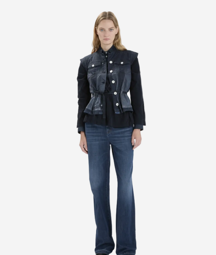 Woman wearing a black denim jacket and blue jeans on a white background