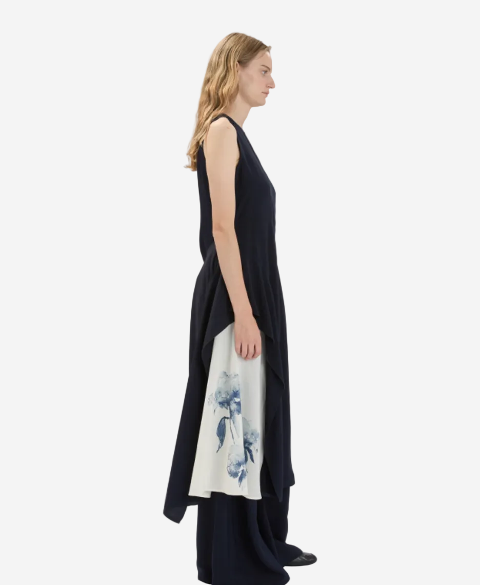Woman wearing a black sleeveless dress with a floral pattern on a white background