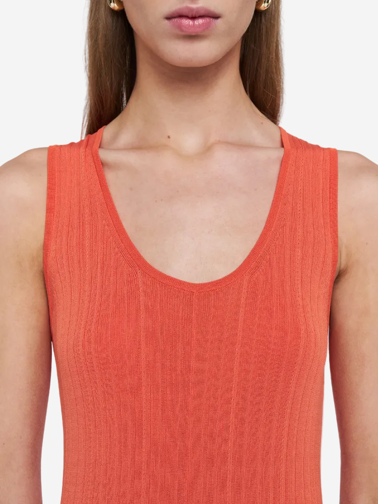 Person wearing a red sleeveless top against a white background