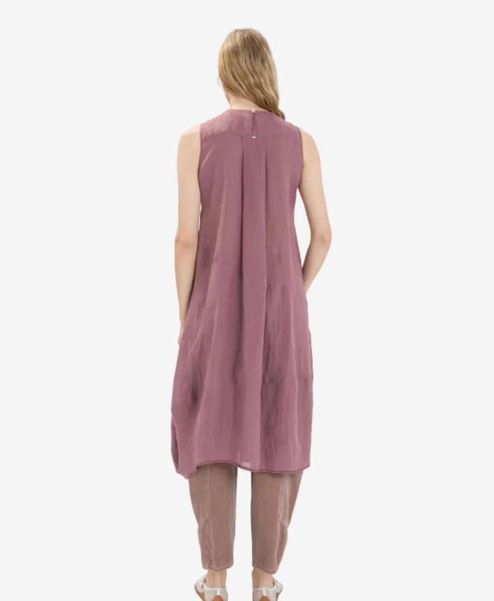 Woman wearing a sleeveless pink dress on a white background