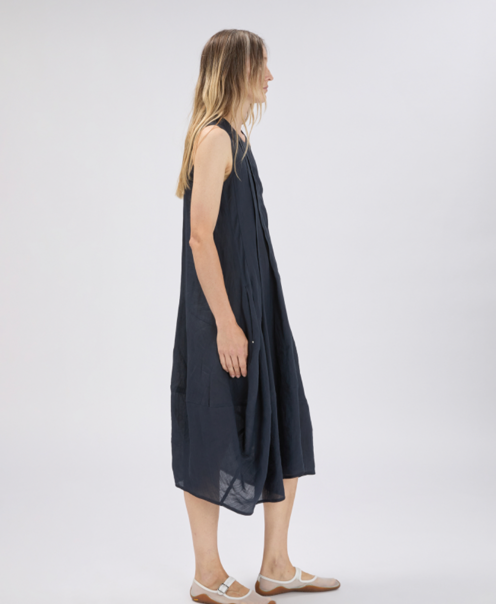 Woman wearing a dark blue sleeveless dress on a white background